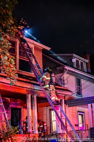 Troy Firefighters Making Their Way To The Roof To Vent The Home