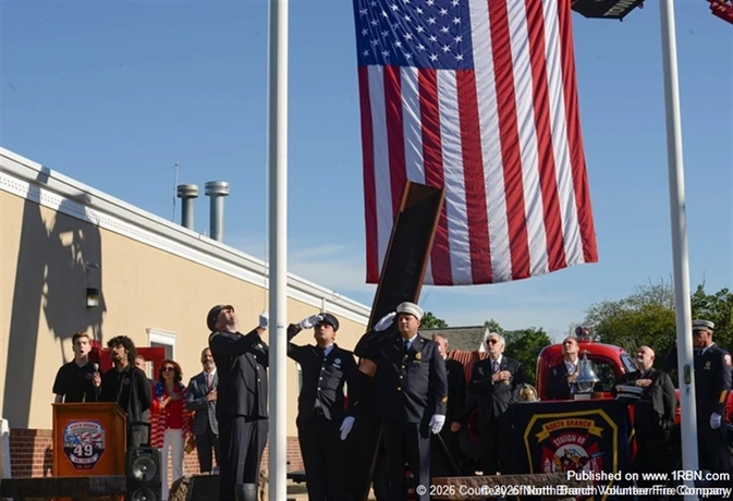 Members of the North Branch Volunteer Fire Company take part in a September 11 remembrance ceremony marking the 25th anniversary of the attacks. The observance included a wreath-laying at a piece of World Trade Center steel displayed outside the firehouse, providing a lasting memorial to those who were lost and the emergency responders who answered the call.