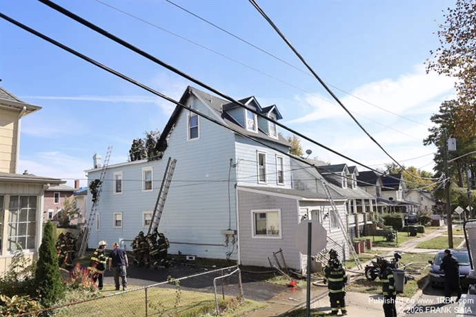 Crews prepare to set extension ladder to more effectively be able to overhaul the rear soffit area.